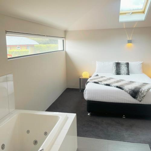 a bedroom with a bed and a bath tub at Fusion Townhouse-North Hobart in West Hobart