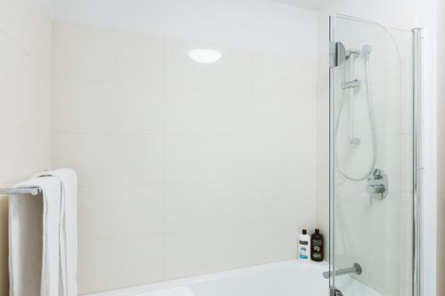 a shower with a glass door in a bathroom at Montage Apartment + Views + Location + Car Parking in Bellerive
