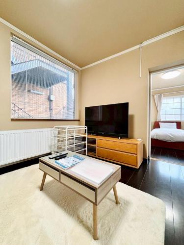 a living room with a tv and a coffee table at 北海道大学ENYA-n17 in Sapporo