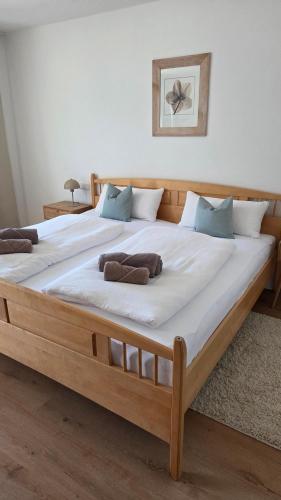 a large wooden bed with two pillows on it at Bachwagnerhof in Staudach-Egerndach