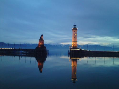 a lighthouse sitting on the water next to a dock at Ferienwohnung Wünsche in Weißensberg