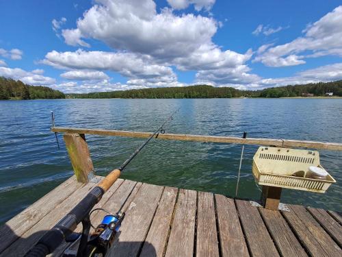 a fishing rod on a dock on a lake at Przystanek Jezioro - Kaszuby in Studzienice