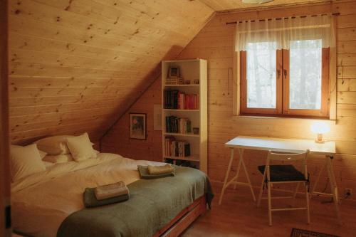 a bedroom with a bed and a desk in a attic at Jarzębinowa - artystyczny dom na Podlasiu in Łuka
