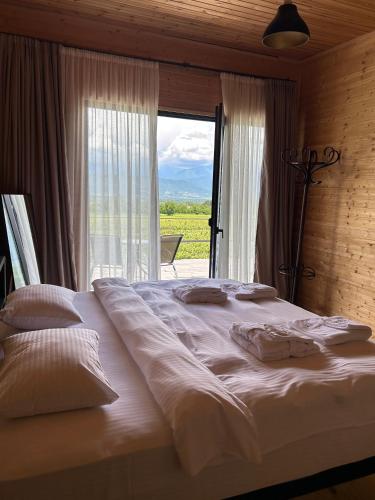 a large bed in a room with a large window at Chateau Resse in Telavi