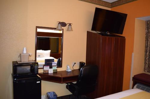a hotel room with a desk and a mirror at Microtel Inn & Suites by Wyndham Rock Hill/Charlotte Area in Rock Hill