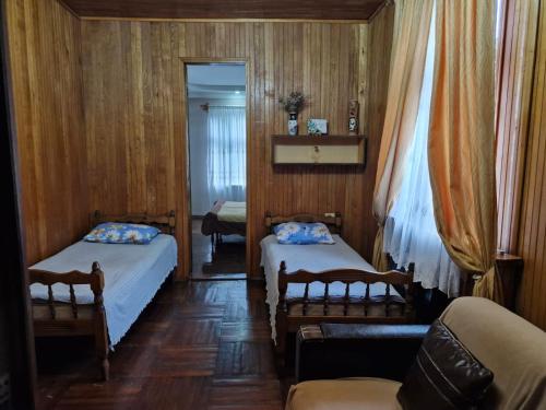 a bedroom with two beds and a couch and a mirror at Guest House Guro kobuleti in Kobuleti