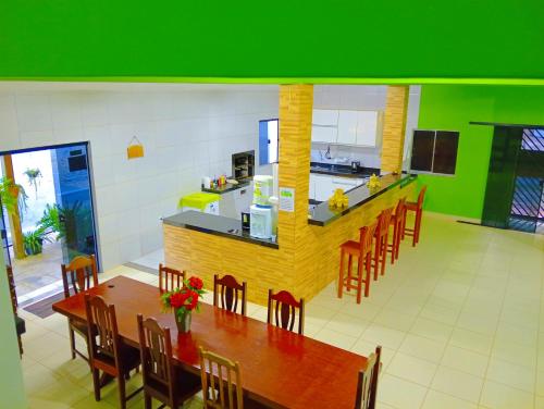 a kitchen with a long wooden table and chairs at Araçagy Casa Mar in São José de Ribamar