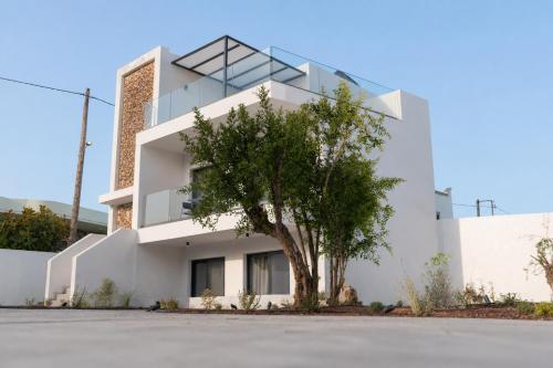 a white house with a tree in front of it at Avli Residences in Kos