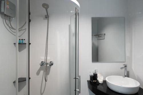 a bathroom with a sink and a glass shower at Baan Chom View Kamala - SHA Plus in Kamala Beach