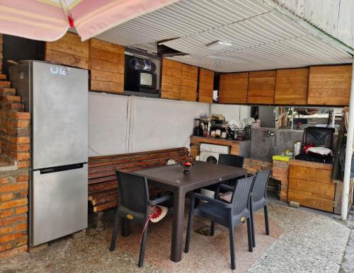 a kitchen with a table with chairs and a refrigerator at Guest House Guro kobuleti in Kobuleti