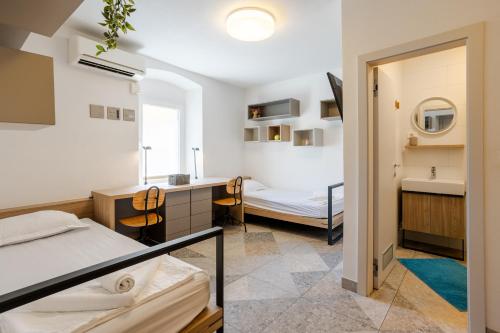 a room with two beds and a desk and a sink at Casa Riccobon in Koper