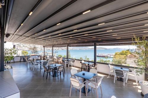 a restaurant with tables and chairs and large windows at ADORA's VIEW HOTEL in Sarandë