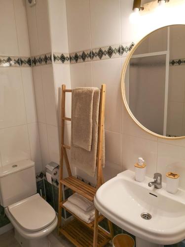 a bathroom with a sink and a toilet and a mirror at Nice apartment with a pool in Fornells