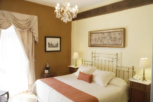 a bedroom with a bed and a chandelier at El Meson de los Poetas in Guanajuato