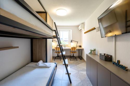 a small room with a bunk bed and a desk at Casa Riccobon in Koper