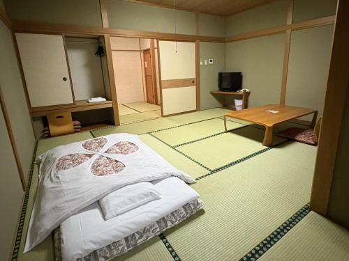 a room with a bed and a table in it at ホテルいづみや in Aizuwakamatsu