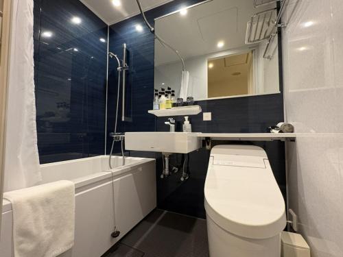 a bathroom with a toilet and a sink and a tub at ホテルいづみや in Aizuwakamatsu