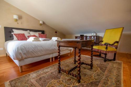 a bedroom with a bed with a desk and a chair at Les Petits Princes, expérience unique à Polignac in Polignac