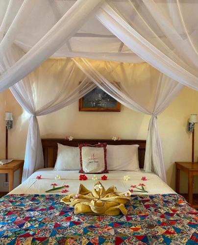 a bedroom with a bed with a stuffed animal on it at Pande Guest House in Pemuteran