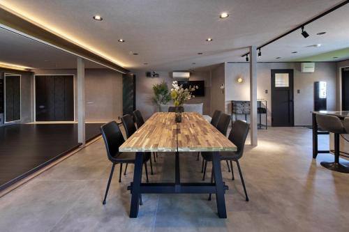 a dining room with a wooden table and chairs at Sauna Villa Biwako Forest Bathing in Takashima