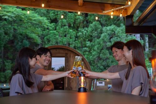 a group of people standing around a bar with a glass of beer at Sauna Villa Biwako Forest Bathing in Takashima