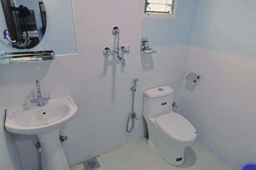 a white bathroom with a toilet and a sink at Manthali Park Inn in Rāmechhāp