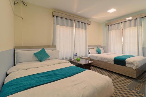 a hotel room with two beds and two windows at Manthali Park Inn in Rāmechhāp