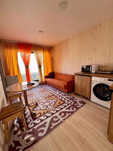 a living room with a couch and a rug at EL House in Karakol