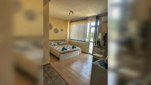 a bedroom with a bed and a kitchen with a window at Боровата къща in Varna City