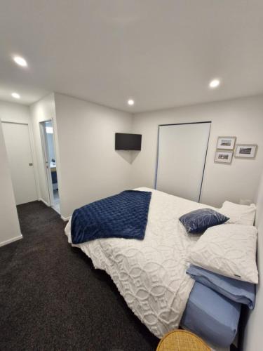 a bedroom with a large bed with blue pillows at Modern Omarama Getaway in Omarama