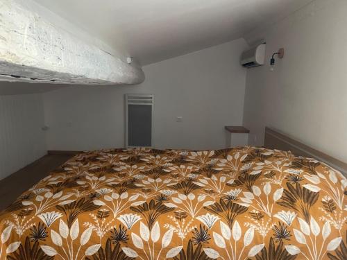 a bed in a room with a blanket on it at Small renovated cozy spot in Palavas-les-Flots