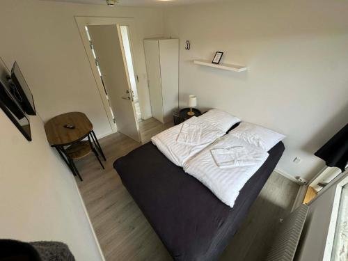 a small bedroom with a bed and a table at Slottets Anneks in Rønne