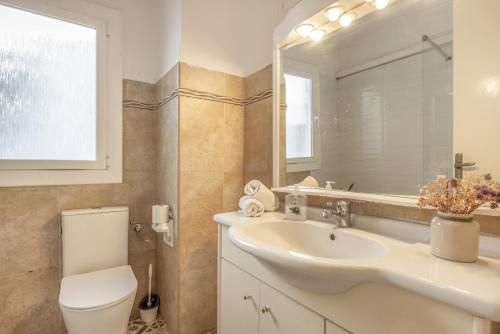 a bathroom with a sink and a toilet and a mirror at Cambrils in Cambrils
