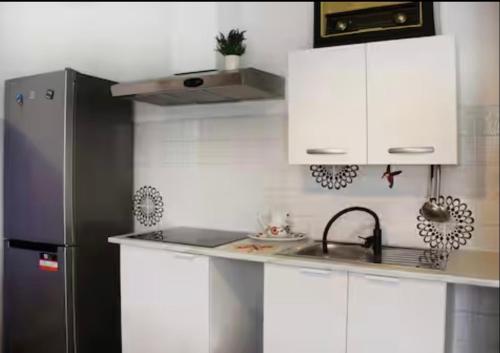 a kitchen with white cabinets and a stainless steel refrigerator at Diamante - relax nature , WiFi in Arcumeggia