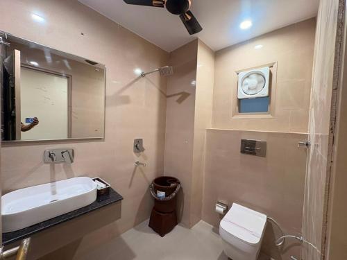 a bathroom with a sink and a toilet and a mirror at Hotel Sunshine Apartment in Bathinda