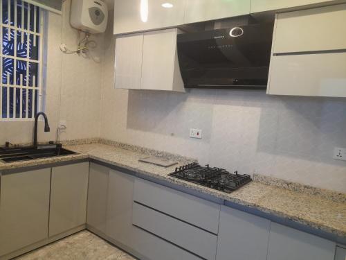 a kitchen with white cabinets and a stove top oven at 5and6 Apartments in Abuja