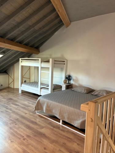a bedroom with a bed and a wooden floor at Le 36 du prieuré in Arbois