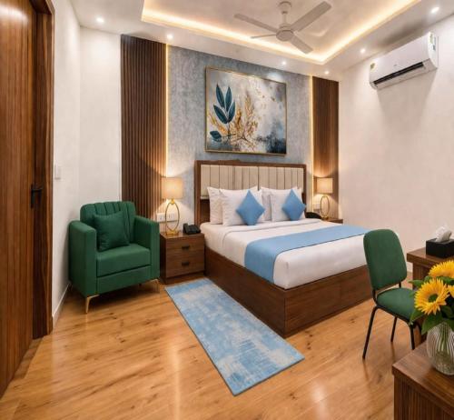 a bedroom with a bed and a green chair at Hotel La Casa Near Delhi Airport in New Delhi