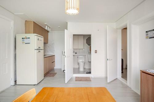 a kitchen with a white refrigerator and a toilet at Stay ongyeol in Suwon