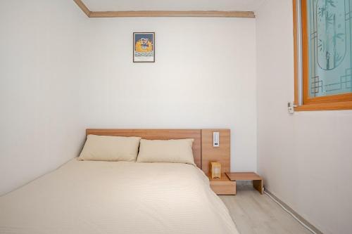 a white bedroom with a bed and a window at Stay ongyeol in Suwon