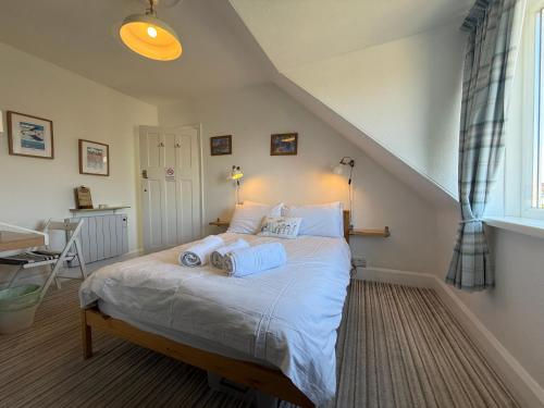 a bedroom with a bed with blue towels on it at Holly Trees Guest Accommodation in Seahouses