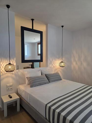a bedroom with a bed with a mirror and two pillows at Triton Authentic Cretan Hotel in Tsoutsouros