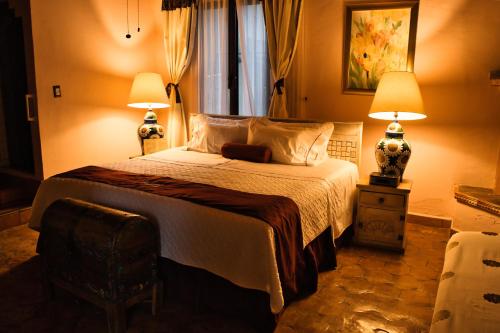 a bedroom with a large bed with two lamps at Villa Bonita Les Terrasses in Cuernavaca