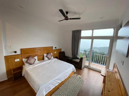 a bedroom with a bed and a large window at Nanda niwas 2 in McLeod Ganj