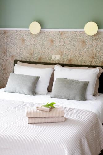 a bedroom with a large white bed with two pillows at B&B Stinzenflora - Gezellige accommodatie tussen groen en historie in Cornjum