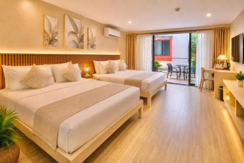 a hotel room with two beds and a balcony at Red Coco Inn de Boracay in Boracay