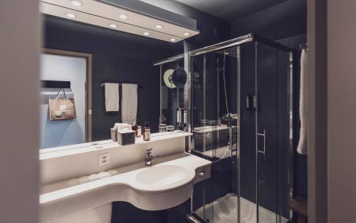 a bathroom with a sink and a shower at Mountain Plaza Hotel in Davos