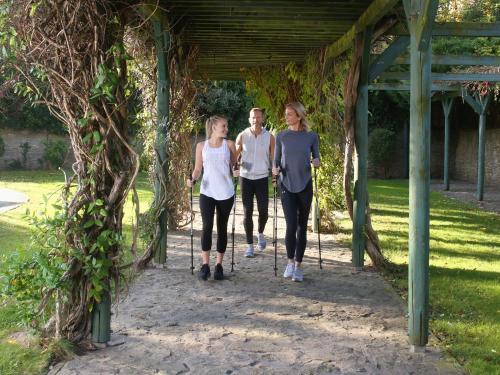 a group of three people walking under a pergola at Hotel Carbona Thermal Spa in Hévíz