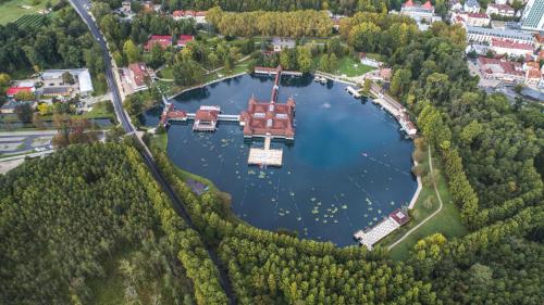 an aerial view of a large building on a lake at Hotel Carbona Thermal Spa in Hévíz