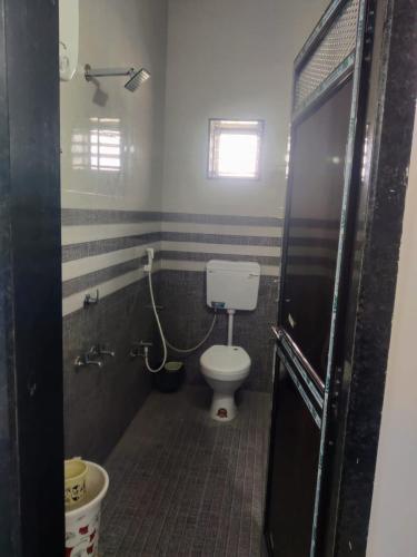 a bathroom with a toilet and a window at Jyoti Hotel and Restaurant in Desuri
